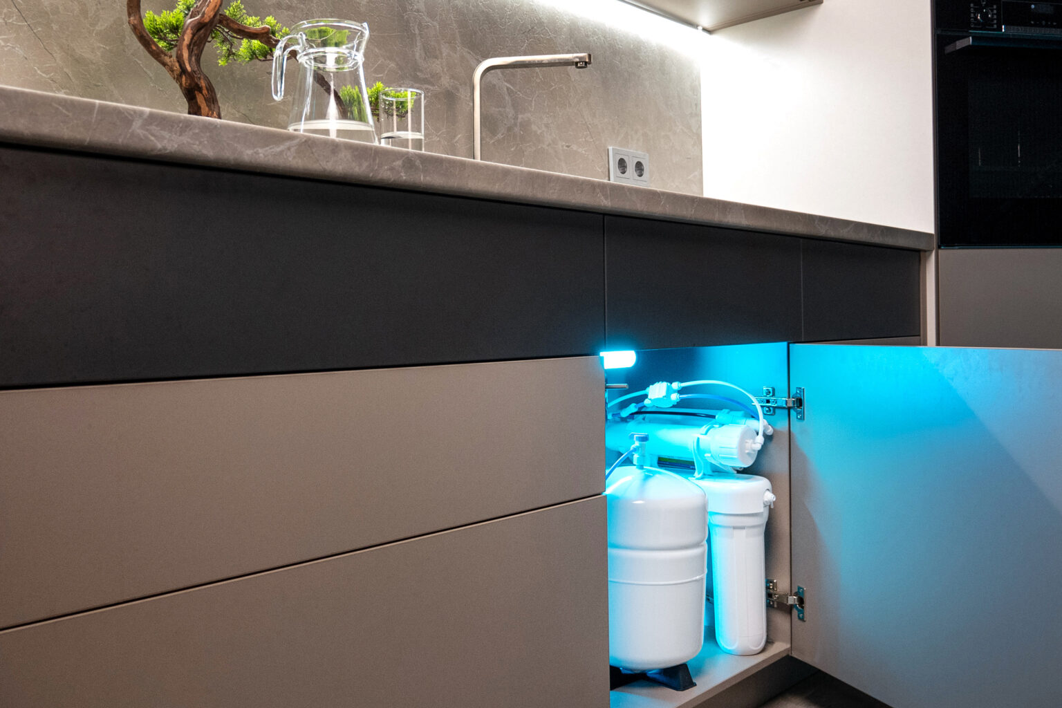 An under-sink reverse osmosis drinking water system installed in a modern kitchen