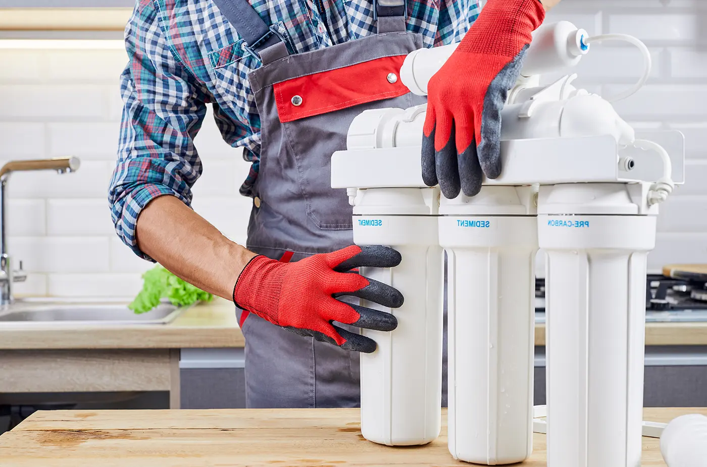 Technician fitting a multi-stage sediment and carbon water filtration system